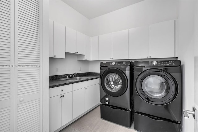 washroom featuring sink, cabinets, and washing machine and clothes dryer