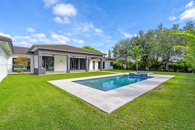 back of property featuring ceiling fan, a swimming pool with hot tub, a yard, and a patio area