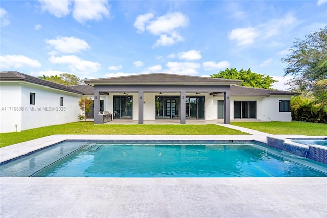 rear view of property with a swimming pool with hot tub, a lawn, ceiling fan, and a patio area