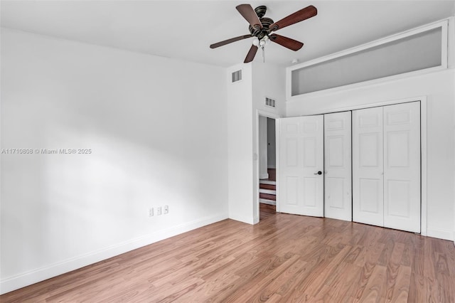 unfurnished bedroom featuring light hardwood / wood-style flooring, ceiling fan, and a closet