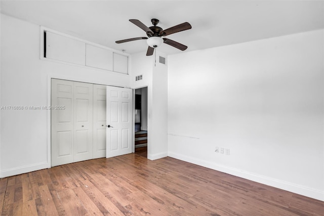 unfurnished bedroom featuring ceiling fan, hardwood / wood-style floors, and a closet