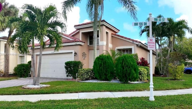 mediterranean / spanish home with a garage and a front yard