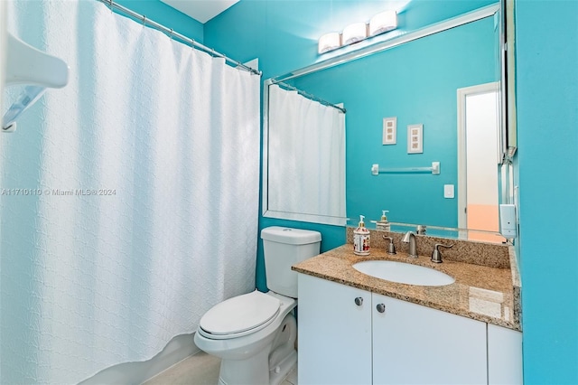 bathroom with vanity, curtained shower, and toilet