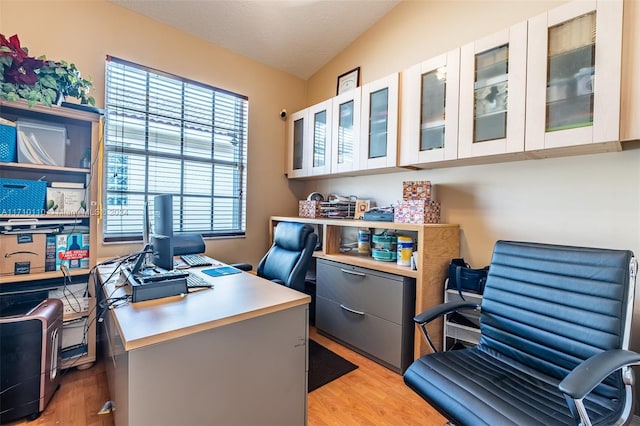 office space with light hardwood / wood-style floors, lofted ceiling, and a textured ceiling