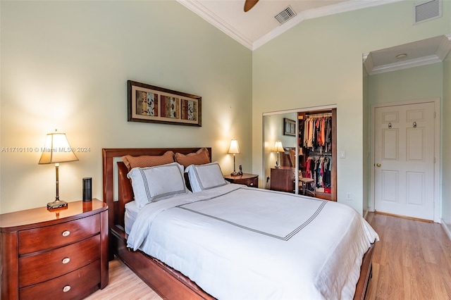 bedroom featuring light hardwood / wood-style floors, a closet, and crown molding