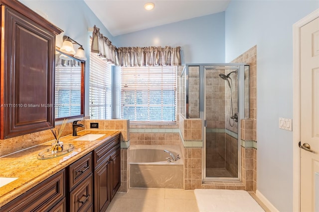 bathroom featuring shower with separate bathtub, vanity, tile patterned floors, and lofted ceiling