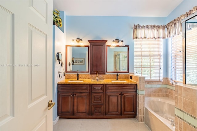 bathroom with vanity, tile patterned floors, plenty of natural light, and a bathing tub