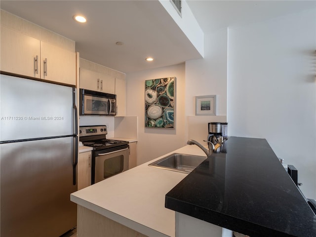 kitchen with kitchen peninsula, stainless steel appliances, and sink