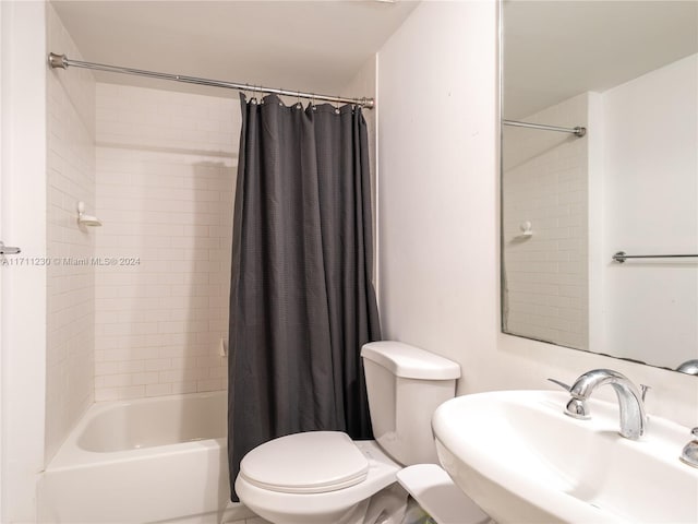 full bathroom with toilet, shower / bathtub combination with curtain, and sink