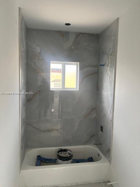 bathroom featuring tiled shower / bath