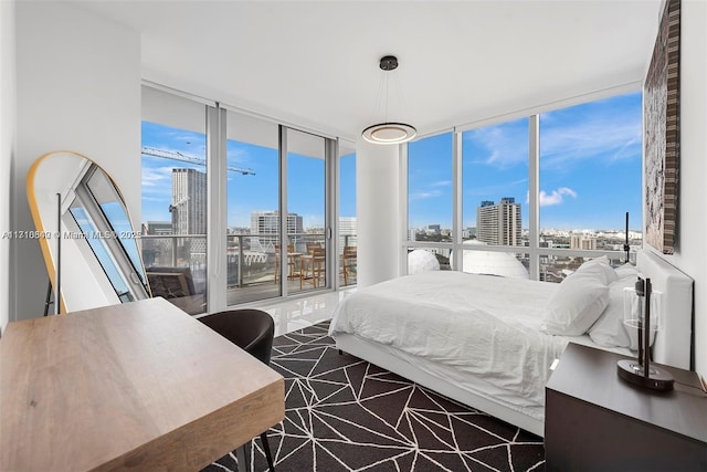 bedroom with floor to ceiling windows and access to exterior