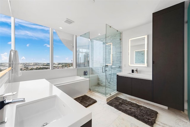 bathroom featuring separate shower and tub and vanity