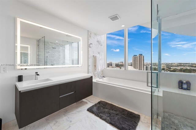 bathroom featuring vanity and independent shower and bath