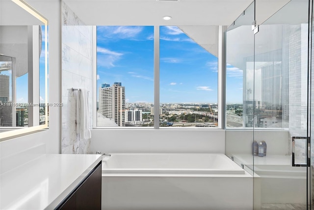 bathroom featuring vanity and shower with separate bathtub