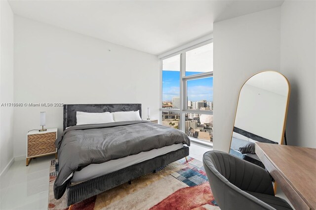 tiled bedroom with multiple windows, expansive windows, and access to exterior