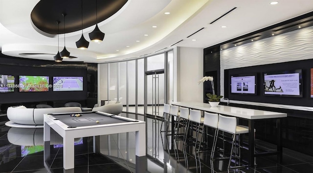 playroom with a tray ceiling, pool table, and bar area