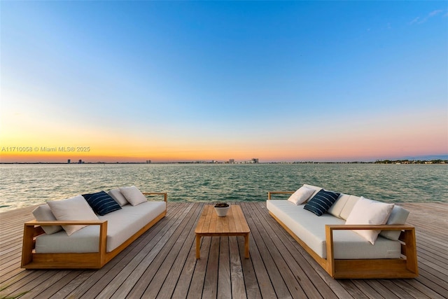 view of dock featuring an outdoor living space and a water view