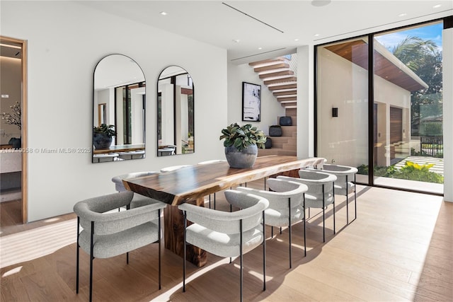 dining room with floor to ceiling windows and light hardwood / wood-style floors