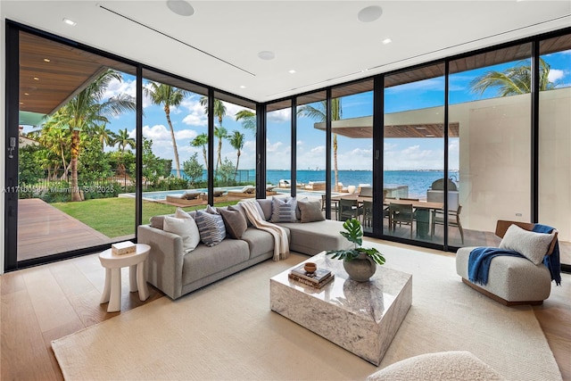 living room with a water view, expansive windows, and light hardwood / wood-style floors