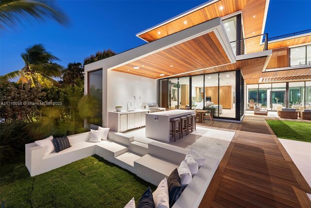 view of patio / terrace featuring an outdoor kitchen, area for grilling, a balcony, and a wet bar