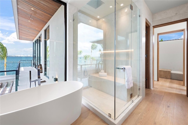 bathroom featuring hardwood / wood-style floors, a water view, wood ceiling, and plus walk in shower