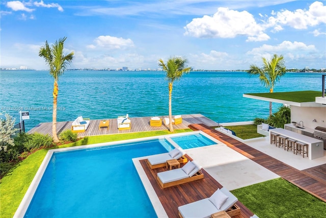 view of swimming pool with a deck with water view and exterior bar