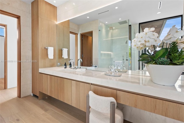 bathroom featuring expansive windows, vanity, hardwood / wood-style flooring, and an enclosed shower