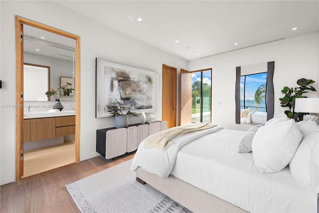 bedroom with access to exterior and light hardwood / wood-style flooring