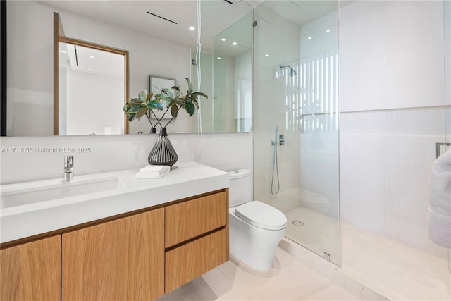 bathroom with toilet, vanity, and tiled shower