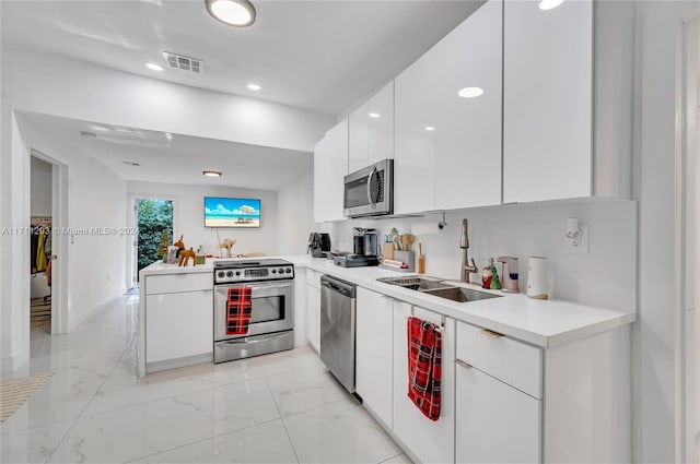 kitchen with white cabinets, sink, kitchen peninsula, and stainless steel appliances