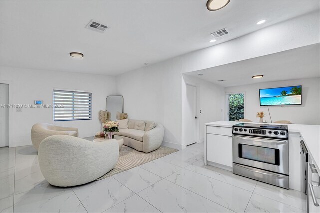living area featuring marble finish floor, visible vents, and a wealth of natural light