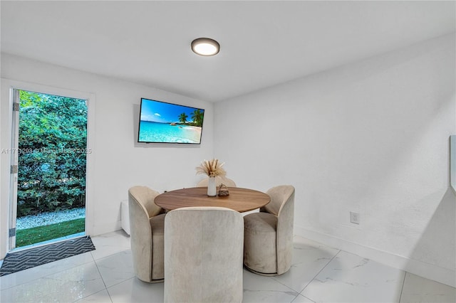 dining space with marble finish floor and baseboards