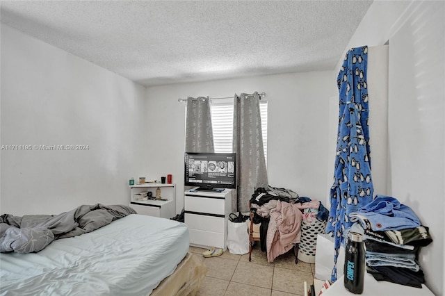 bedroom with light tile patterned floors and a textured ceiling