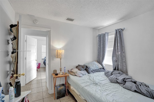 tiled bedroom with a textured ceiling