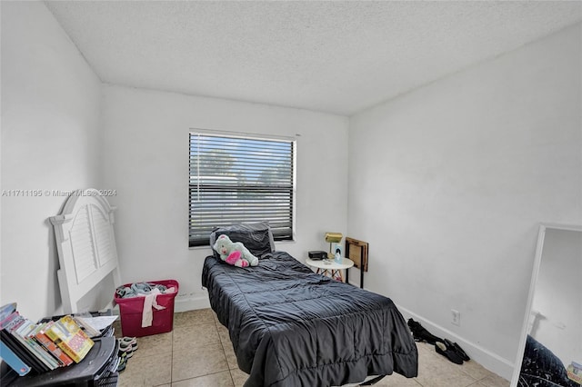 tiled bedroom featuring a textured ceiling