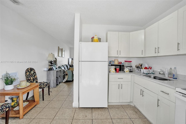 kitchen with white cabinetry, sink, white fridge, a textured ceiling, and light tile patterned floors