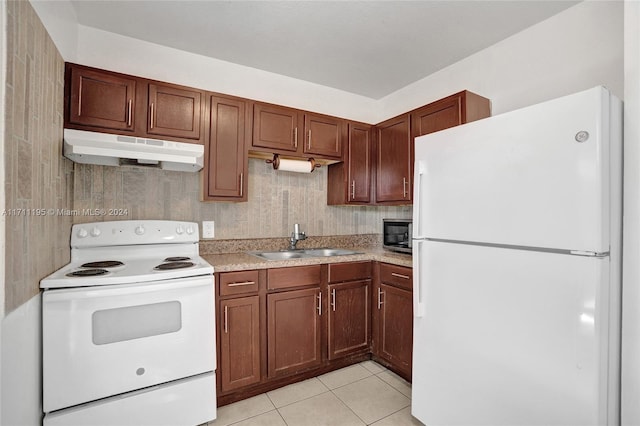 kitchen featuring light tile patterned floors, white appliances, and sink