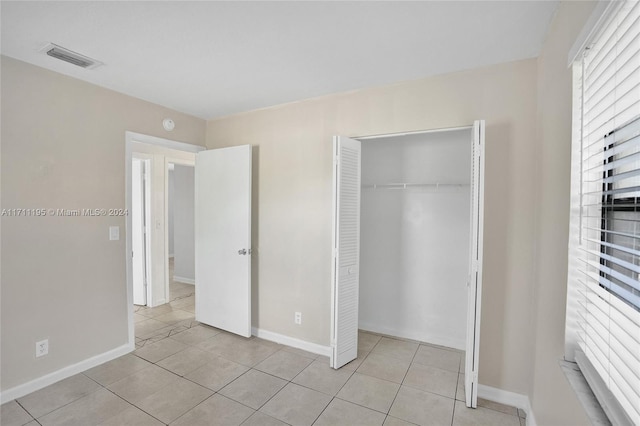 unfurnished bedroom with a closet and light tile patterned floors