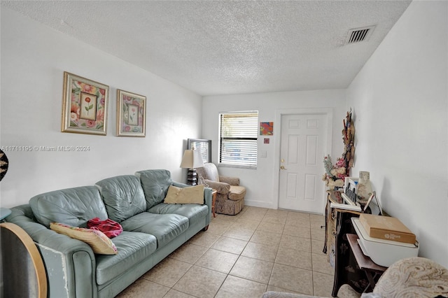 living room featuring light tile patterned flooring and a textured ceiling