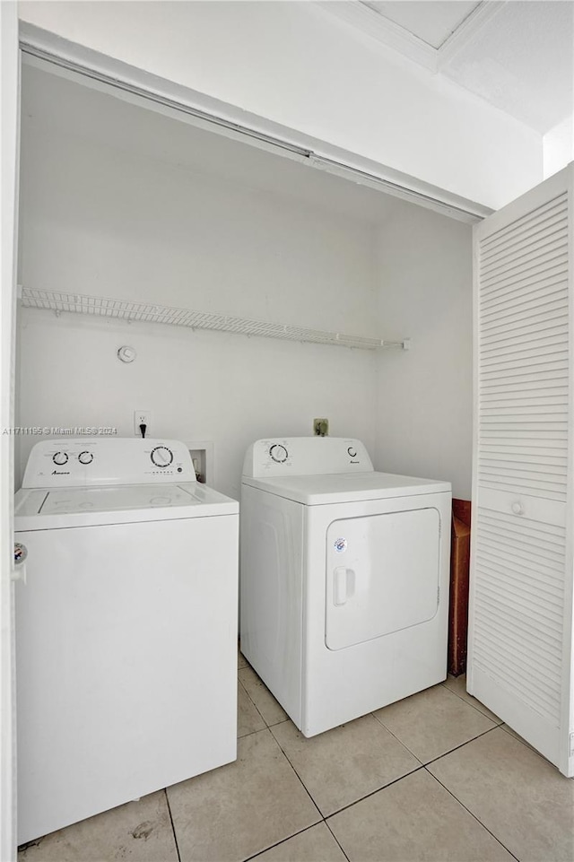 clothes washing area featuring separate washer and dryer and light tile patterned floors