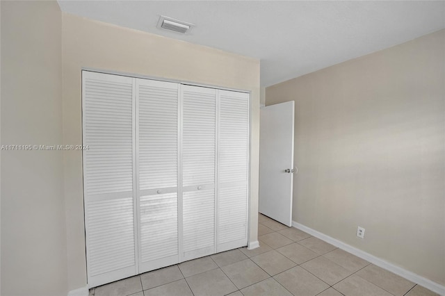 unfurnished bedroom with a closet and light tile patterned flooring