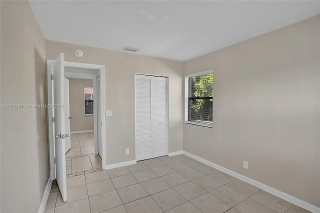 unfurnished bedroom with light tile patterned floors and a closet