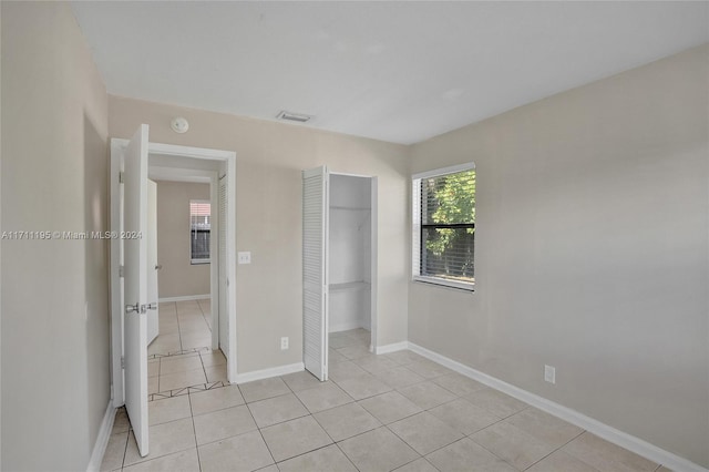 unfurnished bedroom with a closet and light tile patterned flooring