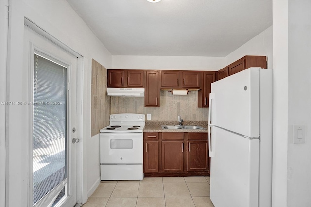 kitchen with light tile patterned floors, white appliances, and sink