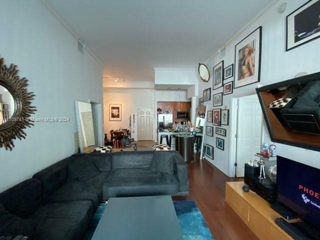 living room featuring dark hardwood / wood-style flooring and ornamental molding