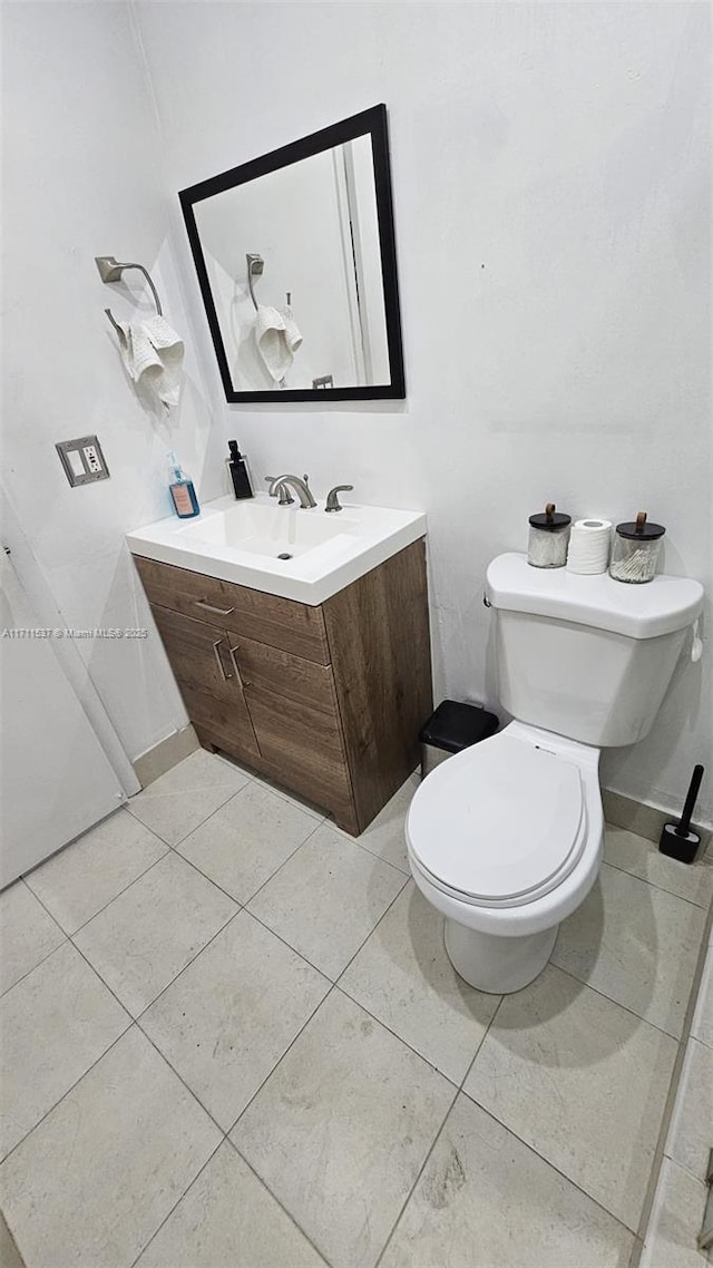 bathroom featuring tile patterned flooring, vanity, and toilet