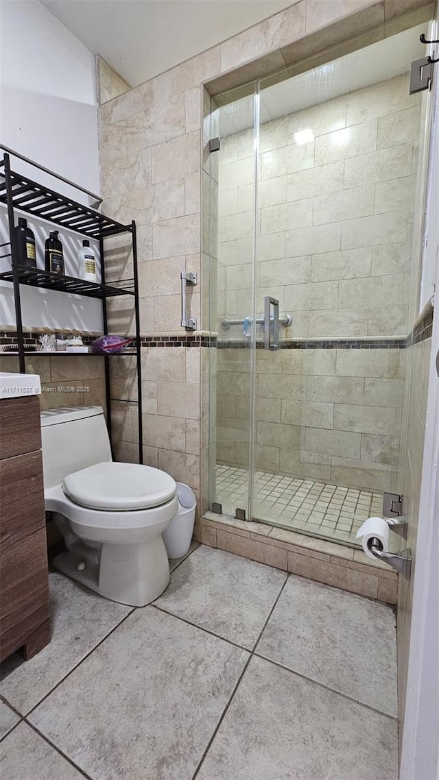 bathroom with toilet, an enclosed shower, and tile patterned flooring