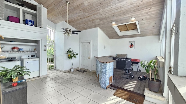 office space with vaulted ceiling, light tile patterned floors, wood ceiling, washer and dryer, and ceiling fan