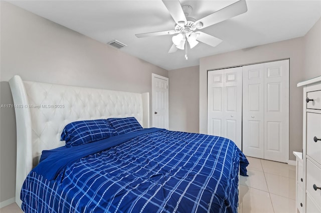 bedroom featuring ceiling fan, a closet, and light tile patterned floors