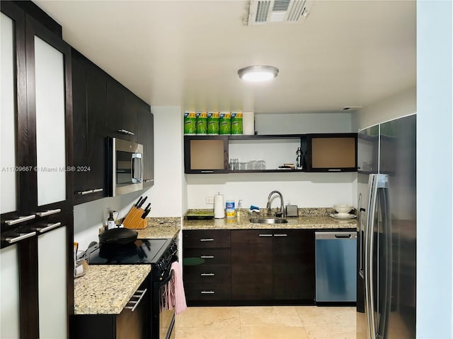 kitchen featuring light stone counters, sink, and stainless steel appliances